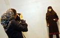 写真は、ショーに出演したモデルの写真を撮るイラン人女性写真家。(c)AFP/BEHROUZ MEHRI