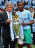 13-14イングランド・プレミアリーグ最終第38節、マンチェスター・シティ（Manchester City）対ウェストハム（West Ham）。トロフィーを手にカメラに向けポーズを取るマンチェスター・シティのヤヤ・トゥーレ（Yaya Toure、右）とマヌエル・ペジェグリーニ（Manuel Pellegrini）監督（2014年5月11日撮影）。(c)AFP/ANDREW YATES