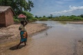 マラウイ南部で、洪水でできた川を歩く女性（2019年3月15日撮影）。(c)AMOS GUMULIRA / AFP