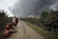 インドネシアの北スマトラ（North Sumatra）州カロ（Karo）で、シナブン山（Mount Sinabung）の噴火による巨大な火山灰雲に飲み込まれた村から避難し、一休みする住民ら（2014年2月1日撮影）。(c)AFP/CHAIDEER MAHYUDDIN