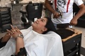 パキスタン東部ラホールの理髪店で、肉切り包丁で髪を切るアリ・アッバスさん（2021年4月8日撮影）。(c)Arif ALI / AFP