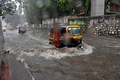 インド西部に大型サイクロンが接近する中、ムンバイの冠水した道路を走る三輪車（2021年5月17日撮影）。(c)Indranil MUKHERJEE / AFP