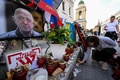 ロシア・モスクワで、死亡が確認されたワグネル創設者エフゲニー・プリゴジン氏の仮設の献花台にろうそくを供える女性（2023年8月27日撮影）。(c)NATALIA KOLESNIKOVA / AFP