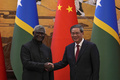 中国・北京で李強首相（右）と握手を交わすソロモン諸島のマナセ・ソガバレ首相（2023年7月10日撮影）。(c)Andy Wong / POOL / AFP