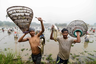 笑みこぼれる 収穫祭で魚捕り インド