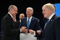 スペインの首都マドリードで開かれた北大西洋条約機構（NATO）首脳会議で、ジョー・バイデン米大統領（中央）とボリス・ジョンソン英首相（右）と談笑するトルコのレジェプ・タイップ・エルドアン大統領（左、2022年6月29日撮影）。(c)GABRIEL BOUYS / AFP