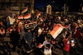 イラク・バグダッドのタハリール広場で、国旗を掲げて反政府デモに参加する人々（2019年10月24日撮影）。(c)AFP