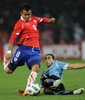 コパ・アメリカ2011（2011 Copa America）1次リーグC組、ウルグアイ対チリ。ウルグアイのマルティン・カセレス（Martin Caceres、右）のタックルを受けるチリのアルトゥーロ・ビダル（Arturo Vidal、2011年7月8日撮影）。(c)AFP/ALEJANDRO PAGNI