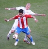 2010年サッカーW杯南アフリカ大会（%%2010 World Cup%%）1次リーグF組、スロバキア対パラグアイ。パラグアイは2-0で勝利した。写真は、スロバキアのマルティン・シュクルテル（%%Martin Skrtel%%）からチェックを受けるパラグアイのルーカス・バリオス（%%Lucas Barrios%%、手前）。（2010年6月20日撮影）(c)AFP/JEWEL SAMAD