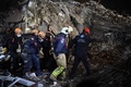 トルコ・イズミルで、倒壊した建物のがれきから収容した地震で死亡した人の遺体を運ぶ救助隊員ら（2020年10月31日撮影）。(c)OZAN KOSE / AFP
