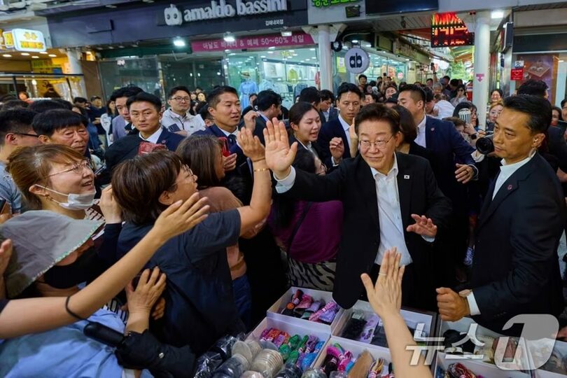 23日、金海の伝統市場を訪れ、市民とあいさつを交わすイ・ジェミョン（李在明）大統領(c)news1