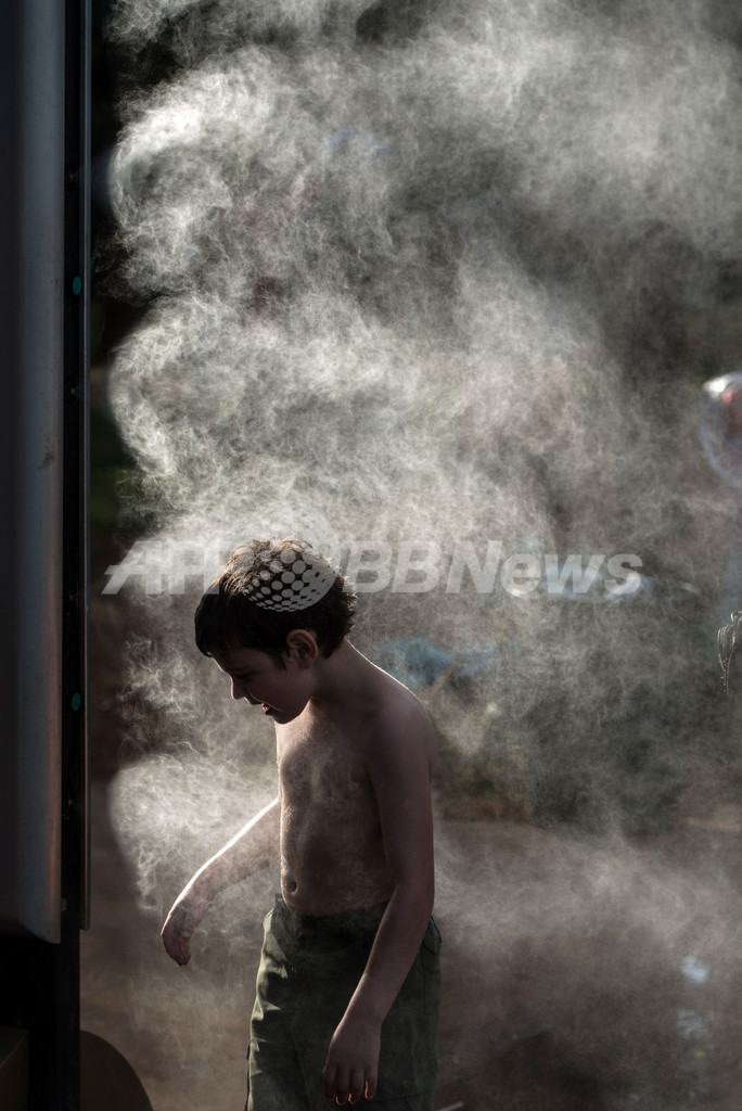 夏へ向かうブラジル、公園でミスト浴びる子どもたち