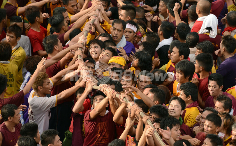 必死、黒いキリスト像に信者が殺到 マニラ