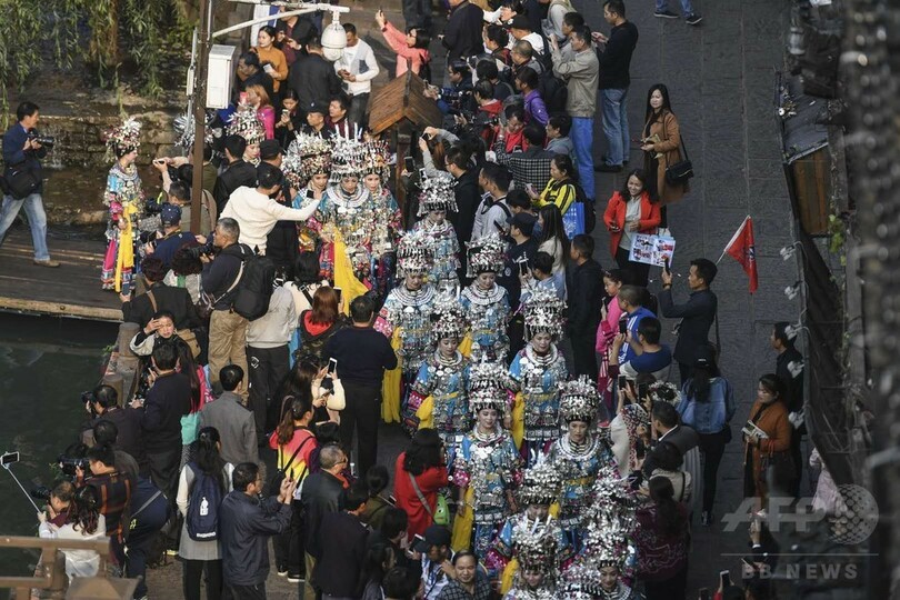 きらびやかな民族衣装が古城に映える　中国・湖南