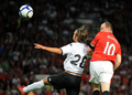サッカー親善試合、マンチェスター・ユナイテッド（%%Manchester United%%）対バレンシア（%%Valencia CF%%）。試合はマンチェスター・ユナイテッドが2-0で勝利した。写真はアレクシス・ルアノ（%%Alexis Ruano%%）に競り勝ち、ヘディングで先制点を挙げるマンチェスター・ユナイテッドのウェイン・ルーニー（%%Wayne Rooney%%、右）。（2009年8月5日撮影）(c)AFP/ANDREW YATES