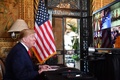 米フロリダ州の別荘「マーアーラゴ」で、世界各地に配置されている米軍兵士らと会話するドナルド・トランプ大統領（2019年12月24日撮影）。(c)Nicholas Kamm / AFP