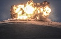 シリア北部のトルコと国境を接する町アインアルアラブ（Ain al-Arab、クルド名：コバニ、Kobane）の丘に対する空爆の爆発のすぐそばに立つイスラム過激派組織「イスラム国（Islamic State、IS）」の戦闘員ら（2014年10月23日撮影）。(c)AFP/BULENT KILIC