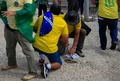 ブラジルの首都ブラジリアの大統領府の外で、襲撃に使うための石を舗道から引きはがそうとするジャイル・ボルソナロ前大統領支持者（2023年1月8日撮影）。(c)Sergio Lima / AFP