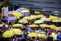 香港民主派による大規模抗議行動「雨傘運動」の4周年を機に行政府本部庁舎の外で行われた集会のさなか、黄色の傘を差す活動家ら（2018年9月28日撮影）。(c)Anthony WALLACE / AFP