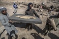 エジプト・ルクソール近郊で発見された古代都市遺構で、出土した魚の化石を運ぶ作業員（2021年4月10日撮影）。(c)Khaled DESOUKI / AFP