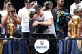 22-23NBAファイナルを制し、地元デンバーのシビック・センターのステージ上でマイケル・マローンHC（中央左）と抱き合うデンバー・ナゲッツのニコラ・ヨキッチ（中央右、2023年6月15日撮影）。(c)Matthew Stockman/Getty Images/AFP