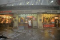 トルコの最大都市イスタンブールで、激しい雨とひょうが降り飲食店などの軒先に避難した人々（2017年7月27日撮影）。(c)AFP/YASIN AKGUL