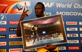 第14回世界陸上モスクワ大会（14th IAAF World Championships in Athletics Moscow）、男子100メートル決勝で撮影された写真を手に、カメラに向かってポーズを取るウサイン・ボルト（Usain Bolt、2013年8月17日撮影）。(c)AFP/FRANCK FIFE