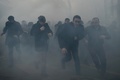 トルコ・イスタンブールにある大手日刊紙ザマン本社前で警察の機動隊から催涙ガスを発射されて逃げ惑う人たち（2016年3月5日撮影）。(c)AFP/OZAN KOSE