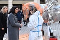 仏パリ中心部で、米国人芸術家チャールズ・レイ氏の彫刻「馬と騎手」にかけられたペンキを除去する作業員と話すリマ・アブデルマラク文化相（左から2人目、2022年11月18日撮影）。(c)Alain JOCARD / AFP
