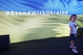 ドバイ万博のウクライナ館で、「#StandWithUkraine（ウクライナと共に）」と表示されたスクリーンの前に立つ少女。アラブ首長国連邦（UAE）ドバイで（2022年2月27日撮影）。(c)Giuseppe CACACE / AFP