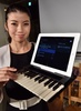 都内で、音楽キーボード（鍵盤）に変身するiPadケース「C.24」を披露するモデル（2014年12月16日撮影）。(c)AFP/Yoshikazu TSUNO