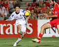 アデレード・ユナイテッドのササ・オグネフスキ（%%Sasa Ognenovski%%）のチェックを受ける前にシュートを放つガンバ大阪の山崎雅人（%%Masato Yamazaki%%）。（2008年11月12日撮影）(c)AFP/William WEST