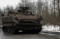 ウクライナ東部バフムート近郊を走行する同国軍の装甲兵員輸送車（2023年4月1日撮影）。(c)Genya SAVILOV / AFP