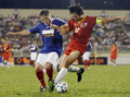 ホーチミン市で行われた親善試合で、元ベトナム代表のレー・フイン・ドゥック（%%Le Huynh Duc%%）と競り合う元フランス代表のマニュエル・アモロス（%%Manuel Amoros%%）氏（左）。(c)AFP