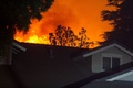米カリフォルニア州ポーターランチの住宅に迫るサドルリッジ森林火災の炎（2019年10月11日撮影）。(c)DAVID MCNEW / AFP