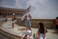 スペイン・セビリアで、噴水の水で涼を取る人（2022年6月12日撮影）。(c)JORGE GUERRERO / AFP