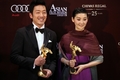 香港（Hong Kong）で開かれた第5回アジア・フィルム・アワード（Asian Film Awards）の授賞式で、主演男優賞を獲得した韓国のハ・ジョンウ（Ha Jung-Woo、左）と主演女優賞を獲得した中国のシュイ・ファン（Xu Fan、2011年3月21日撮影）。(c)AFP/ED JONES