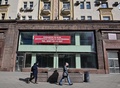 ロシア・モスクワ中心部の繁華街トベルスカヤ通りで、閉店した店舗の前を歩く人々（2022年3月16日撮影）。(c)AFP