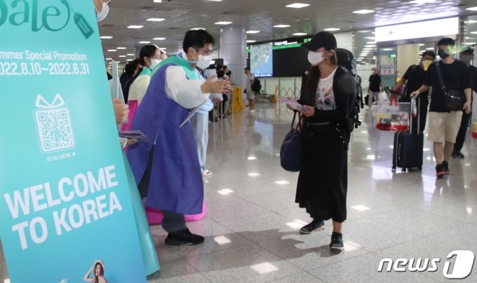 金海国際空港国際線庁舎で、ビザなし入国が許可された日本人観光客を迎える釜山観光公社職員ら(c)news1