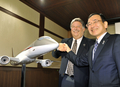 都内の会見で、小型ジェット旅客機「三菱リージョナルジェット（Mitsubishi Regional Jet、MRJ）」100機受注を発表し、笑顔で握手する三菱航空機（Mitsubishi Aircraft）の江川豪雄（Hideo Egawa）社長（左）とトランス・ステーツ・ホールディングス（Trans States Holdings、TSH）のリチャード・リーチ（Richard Leach）社長（2009年10月2日撮影）。(c)AFP/Yoshikazu TSUNO