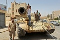 リビアの国民統一政府（GNA）側が奪還した同国西部のタルフナで、戦車の車体の上に乗ったGNA側の戦闘員ら（2020年6月5日撮影）。(c)Mahmud TURKIA / AFP