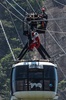 ブラジル・リオデジャネイロ（Rio de Janeiro）で、パン・デ・アスーカル山（Pao de Acucar）にあるロープエーのワイヤロープを滑車で滑り降りるサンタクロース姿の男性（2014年12月18日撮影）。(c)AFP/YASUYOSHI CHIBA