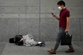 東京・有楽町駅のそばの歩道で眠る男性（2020年6月18日撮影）。(c)CHARLY TRIBALLEAU / AFP