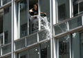 2007年12月31日、ウルグアイのモンテビデオ（Montevideo）で、ビルの窓から水をまく男性。(c)AFP/Pablo Porciuncula