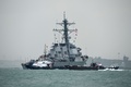 シンガポールのチャンギ海軍基地沖で、タグボートに誘導される米海軍の駆逐艦「ジョン・S・マケイン」（2017年8月21日撮影）。(c)AFP/ROSLAN RAHMAN