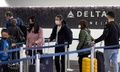 米カリフォルニア州ロサンゼルスの空港でチェックインのため並ぶ旅行客（2021年12月24日撮影）。(c)DAVID MCNEW / AFP
