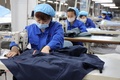 北京冬季五輪の関係者が着用する防護服を作る作業員。中国・山東省浜州市で（2022年1月27日撮影）。(c)AFP