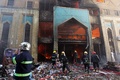 爆弾2発の爆発後に建物が炎上したイラク・バグダッド（Baghdad）市内のショルジャ（Shorjah）市場で、消火活動にあたる消防隊員ら（2014年2月13日撮影）。(c)AFP/AHMAD AL-RUBAYE