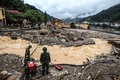 ベトナム北部イエンバイ省の山間部の鉄砲水に襲われた町で、排水作業をする兵士ら（2017年8月4日撮影）。(c)AFP