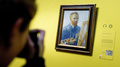 再開したオランダ・アムステルダム（Amsterdam）のゴッホ美術館（Van Gogh Museum）で、ビンセント・ファン・ゴッホ（Vincent van Gogh）作の自画像の写真を撮る来館者（2013年5月1日撮影）。(c)AFP/ANP/KOEN VAN WEEL